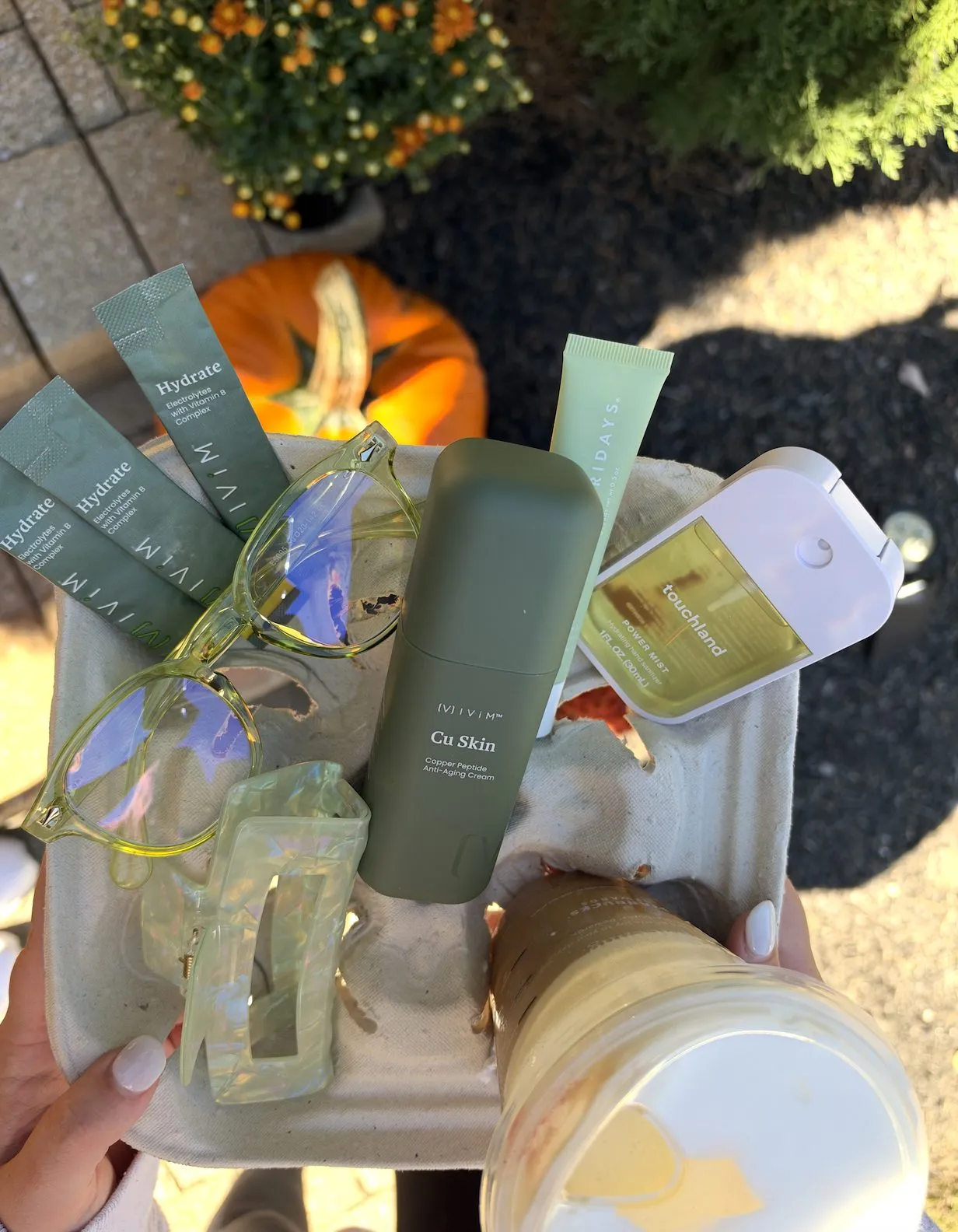 Fall flat-lay of Ivím products with pumpkin and mums